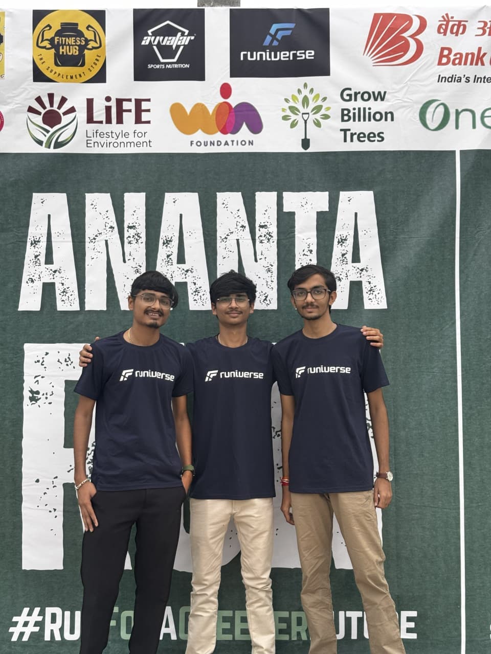 The three Runiverse founders in Runiverse shirts in front of the Ananta Run banner.